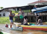 Satlantas Polresta Pekanbaru Bagi Sembako untuk Nelayan Sungai Siak